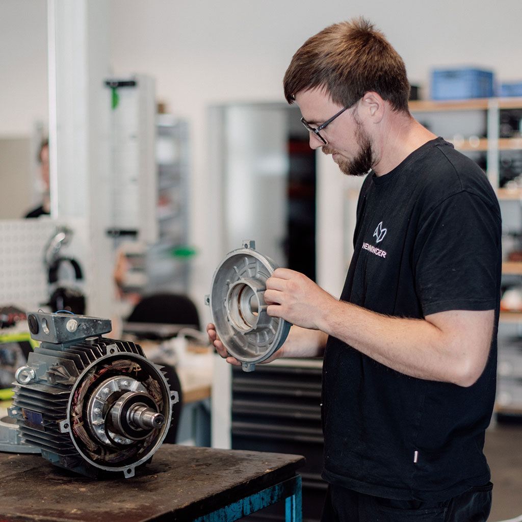 Mitarbeiter prüft einen zerlegten Elektromotor