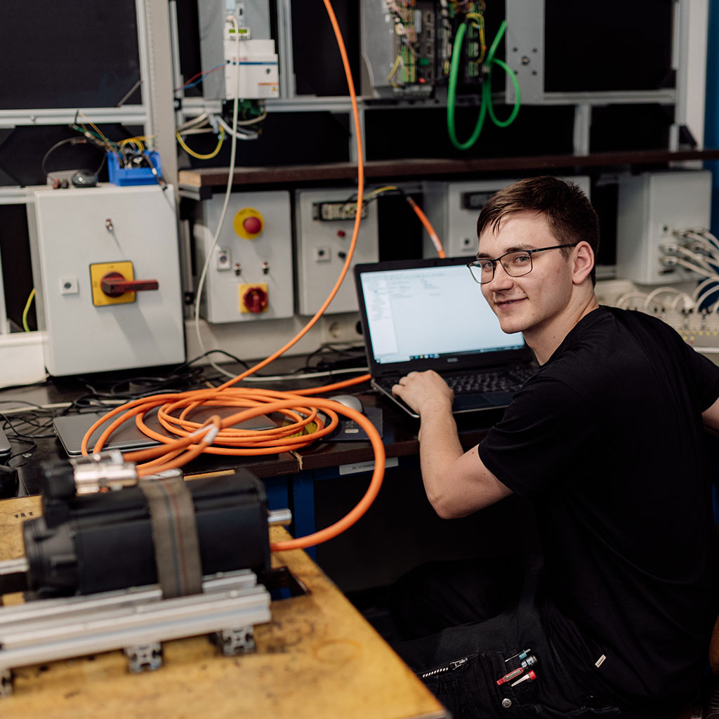 Mitarbeiter am Prüfstand mit Laptop