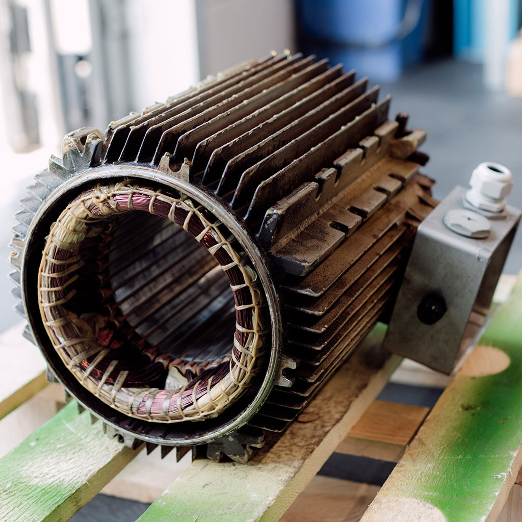 Stator eines Elektromotors mit Kühlrippen auf einer Holzpalette
