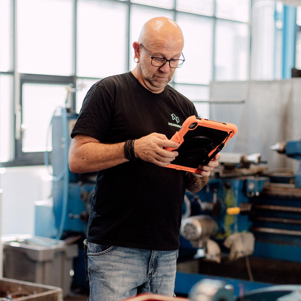 Mitarbeiter mit Messgerät in der Werkstatt