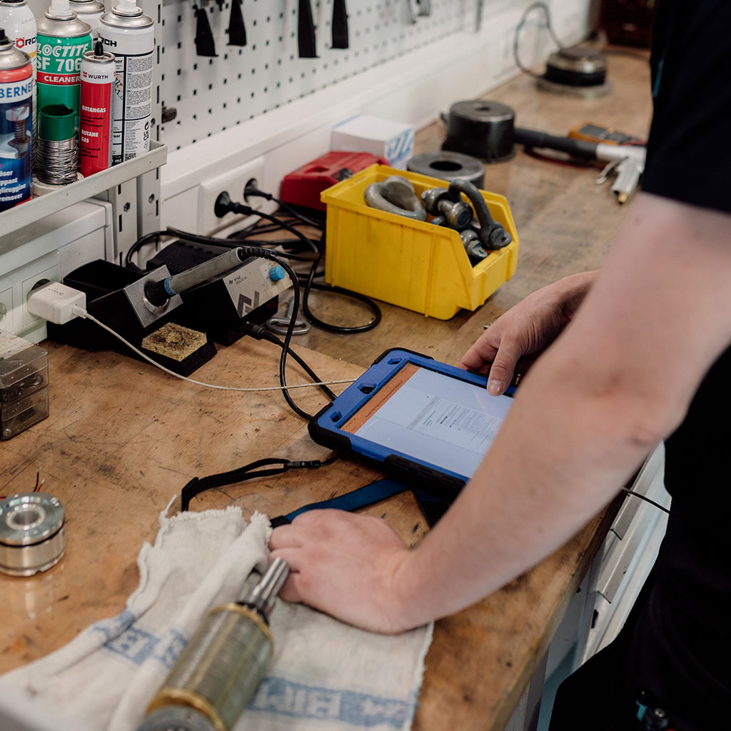 Mitarbeiter mit Tablet an der Werkbank